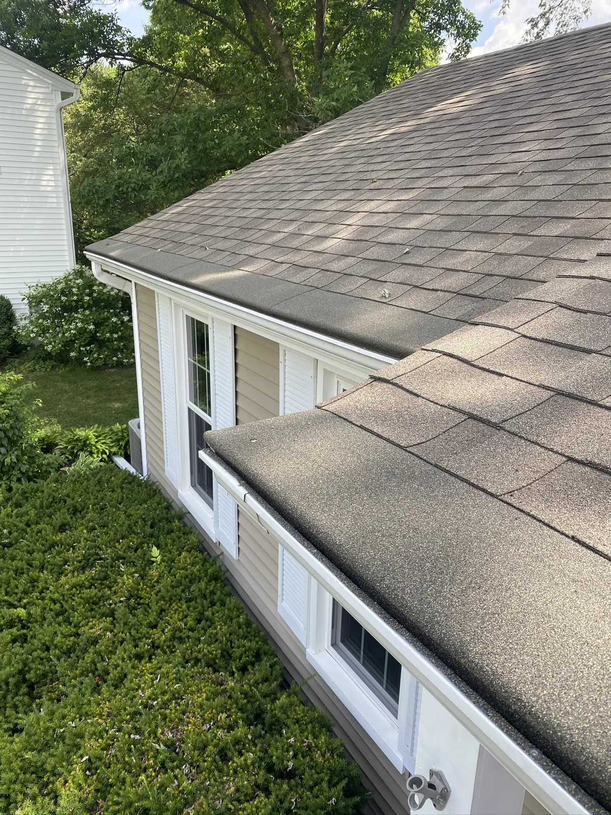 Turtle Shell cap wrapping the eaves at the corner of a beige-sided home